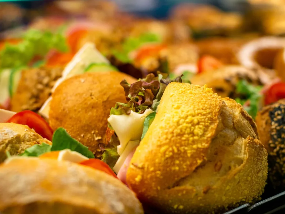 Frisch belegte Brötchen mit Käse, Schinken, Salat und Tomate in der Theke