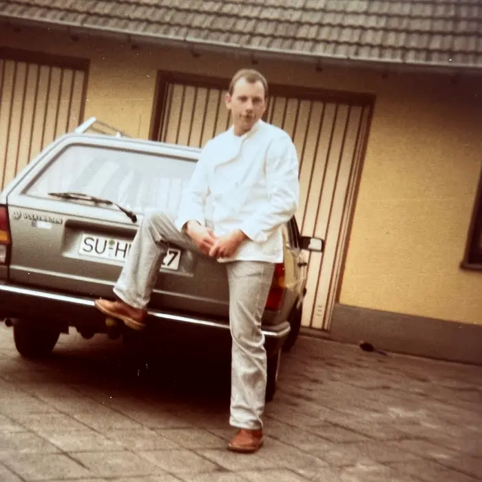 Dietmar Müller in Bäckerjacke vor der Backstube